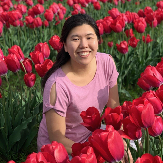 Portrait of Iris sitting in a field of red tulips