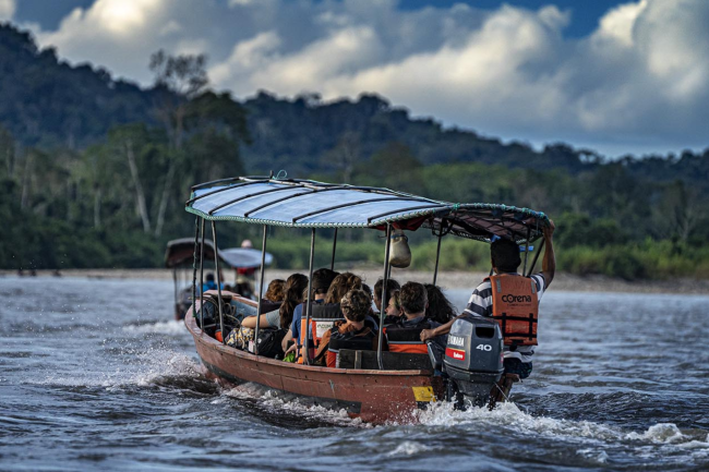 Students on a boat riding through the Amazon