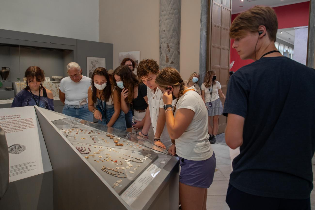 Students crowd around a display of jewelry in the National Archaeological Museum in Athens