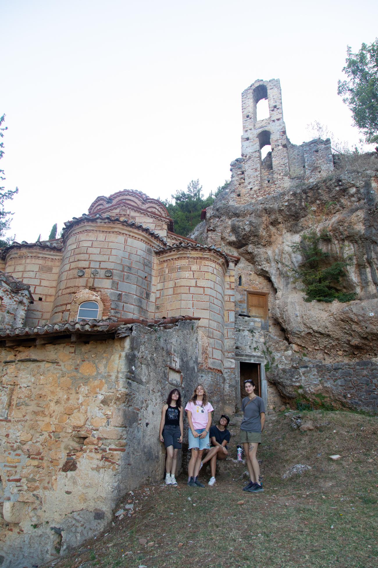 Sophia, Zoey, Indigo, and Violet smile in front of ruins of ancient Mystras