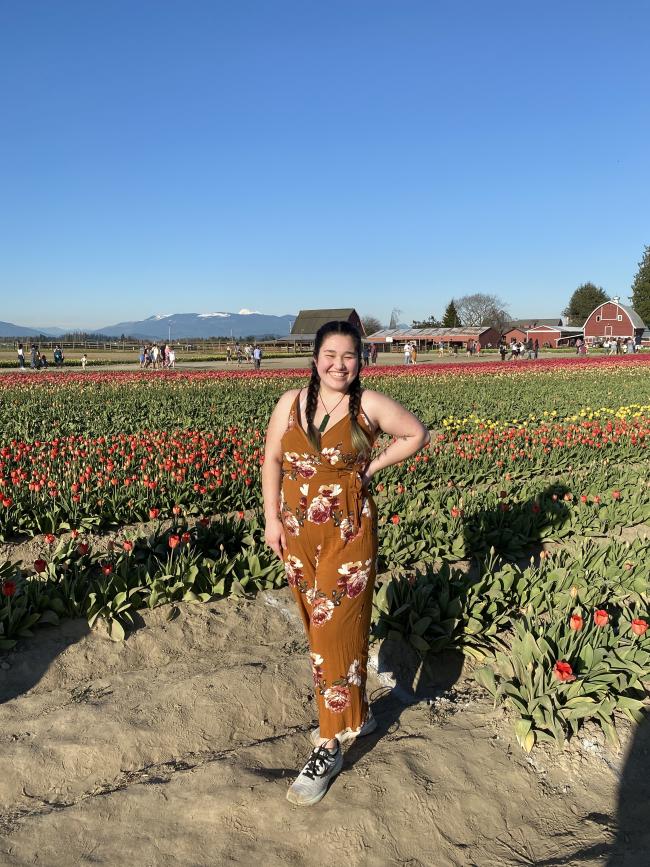 Chiyo wears a jumpsuit and poses in a field of tulips